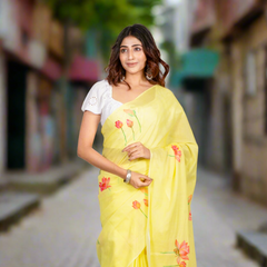 Woman wearing a yellow saree with floral patterns on a gray background